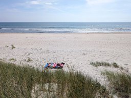Entspannung in der Sonne an einem ungewohnt ruhigen Sandstrand